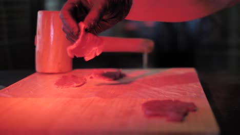 Chef-tenderize-raw-beef-meat-with-wooden-mallet,-close-up