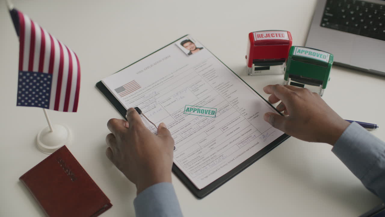 Close-Up of Visa Officer Stamping Approval on Application Form