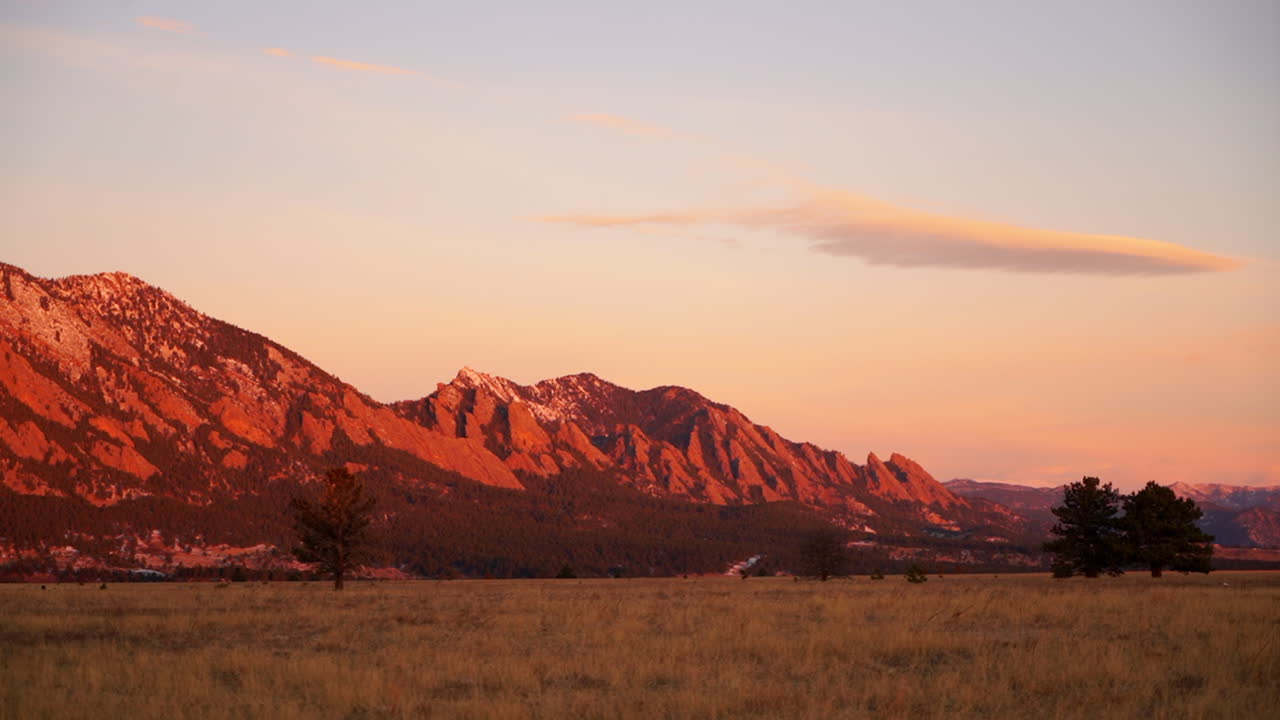 impresionante naranja intenso rosa amanecer atardecer colorado universidad roca planchas finales otoño invierno muerto hierba amarilla nieve en rocas rojas picos temprano en la mañana panorámica hacia la izquierda cámara lenta