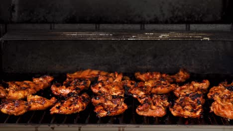 Men's-hand-opening-a-grill-to-check-on-the-BBQ-chicken-as-a-flame-flares-up---still-tripod-shot