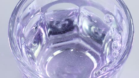 bubbles exploding in the surface of a glass of water