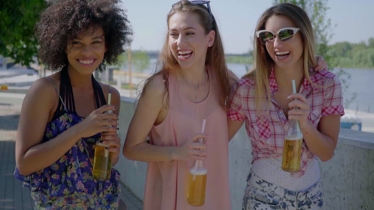 mujeres felices bebiendo cerveza en la ciudad