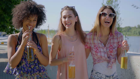 happy women drinking beer in city