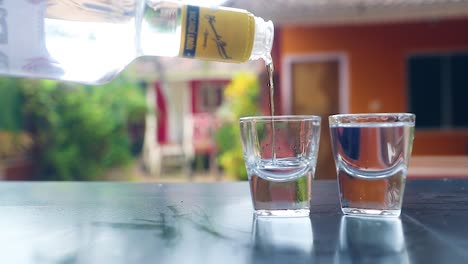 Pouring 'Bacardi White Rum' to Vodka Glasses, Slow Motion Shot