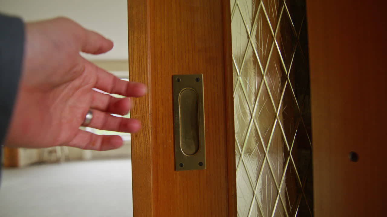Walking to an old sliding door and opening the door to the right