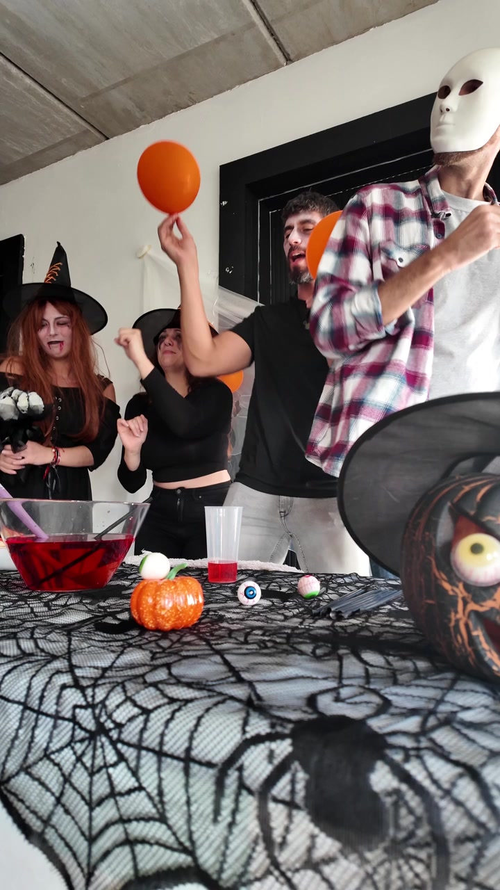 Przyjaciele tańczący w kostiumach na imprezie halloweenowej