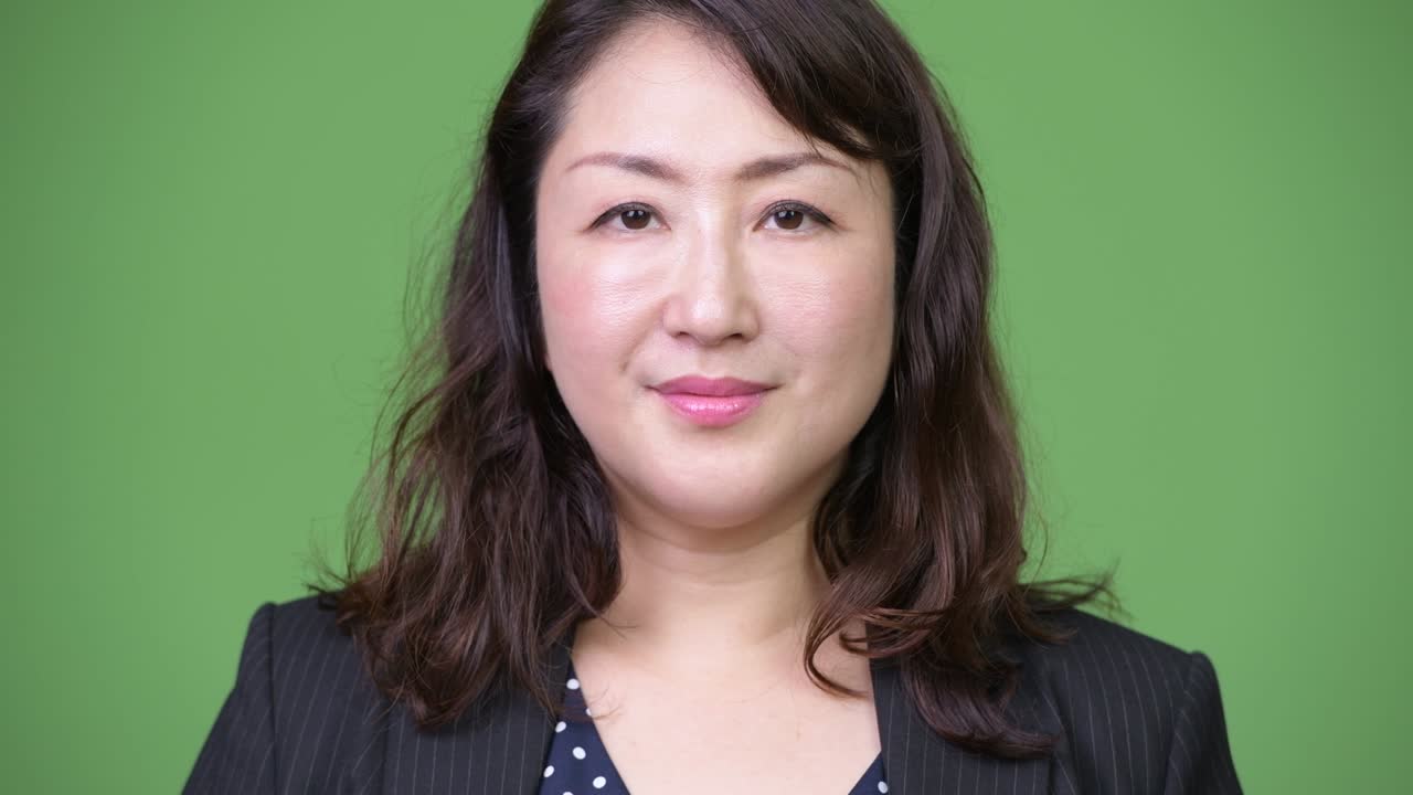 녹색 배경에 성숙한 아름다운 아시아 사업가