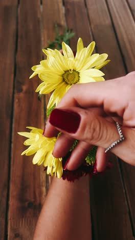 mujer sosteniendo un ramo de flores en una mesa de madera