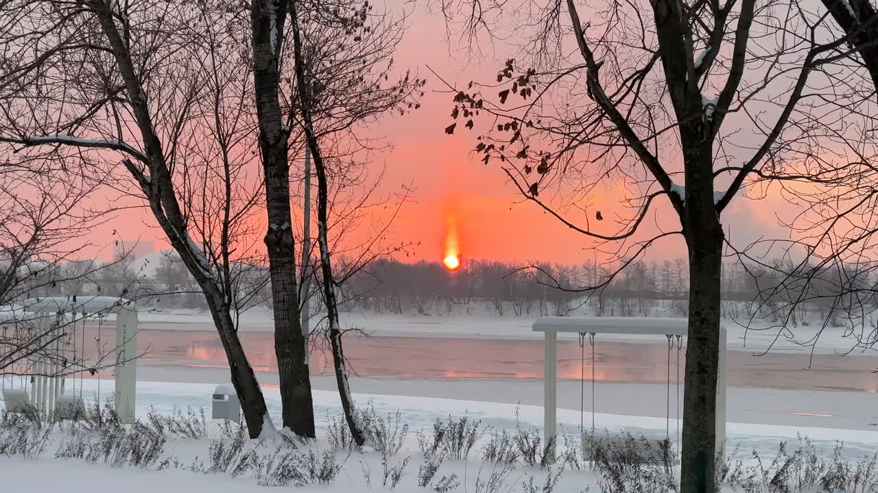 Den flammende morgengry over elven om vinteren