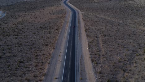 Fotografía-Cenital-Que-Muestra-Un-Automóvil-Conduciendo-Lentamente-Hacia-El-Cañón-De-Roca-Roja-Al-Amanecer.