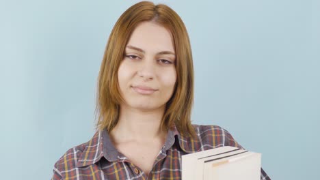 close-up of young female student holding a book.