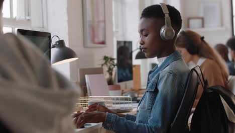 Joven-Mujer-De-Negocios-Afroamericana-Que-Usa-Una-Computadora-Escribiendo-En-El-Teclado-Enviando-Correos-Electrónicos-En-Red-En-Una-Oficina-Ocupada-Revisando-El-Teléfono-Inteligente