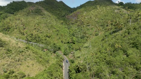 antena: disparo de un dron siguiendo a un automóvil que gira alrededor de una colina