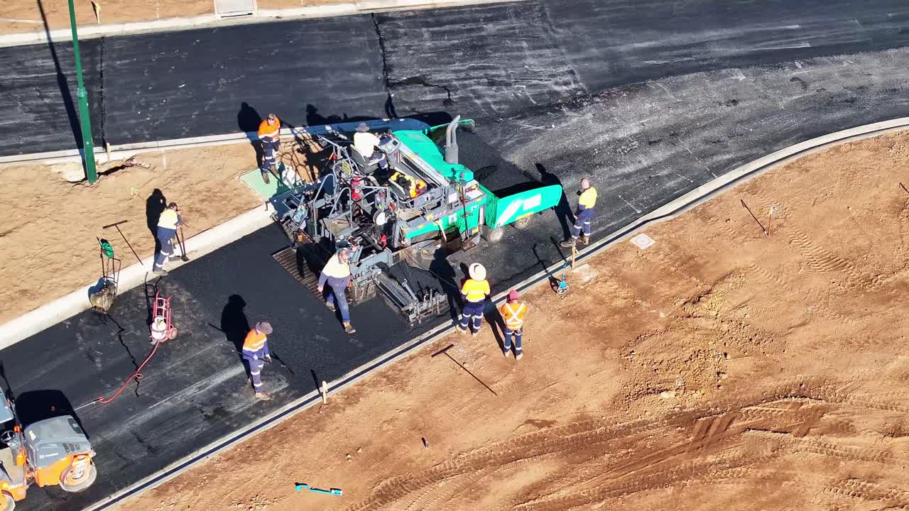 Aerial View of Road Construction with Asphalt Paver and Workers