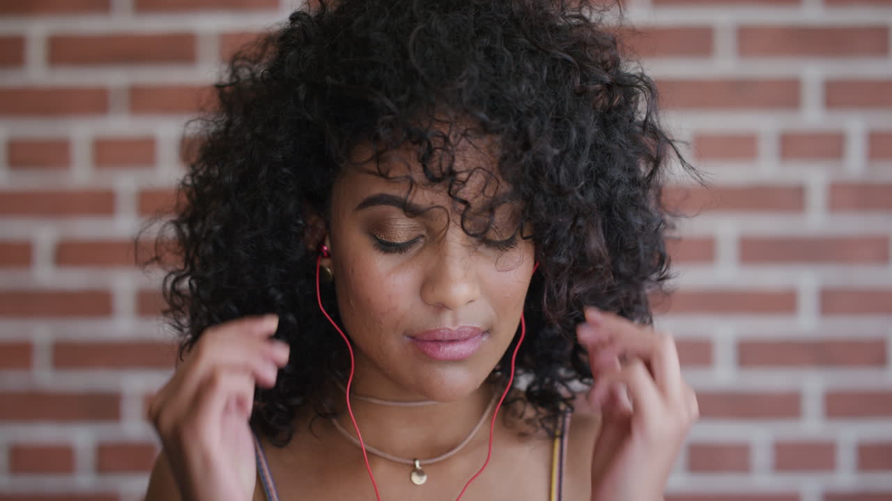 retrato hermosa joven mujer hispana se pone auriculares disfrutando escuchando música bailando entretenimiento relajado cámara lenta