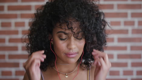 portrait-beautiful-young-hispanic-woman-puts-on-earphones-enjoying-listening-to-music--dancing-relaxed-entertainment-slow-motion