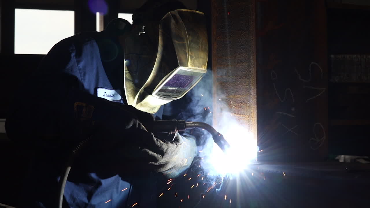 A man welding beams for a walking bridge in slow motion