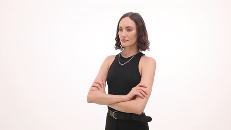elegant young woman with short hair posing with arms crossed on white background
