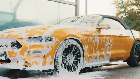 yellow convertible car being washed at a car wash