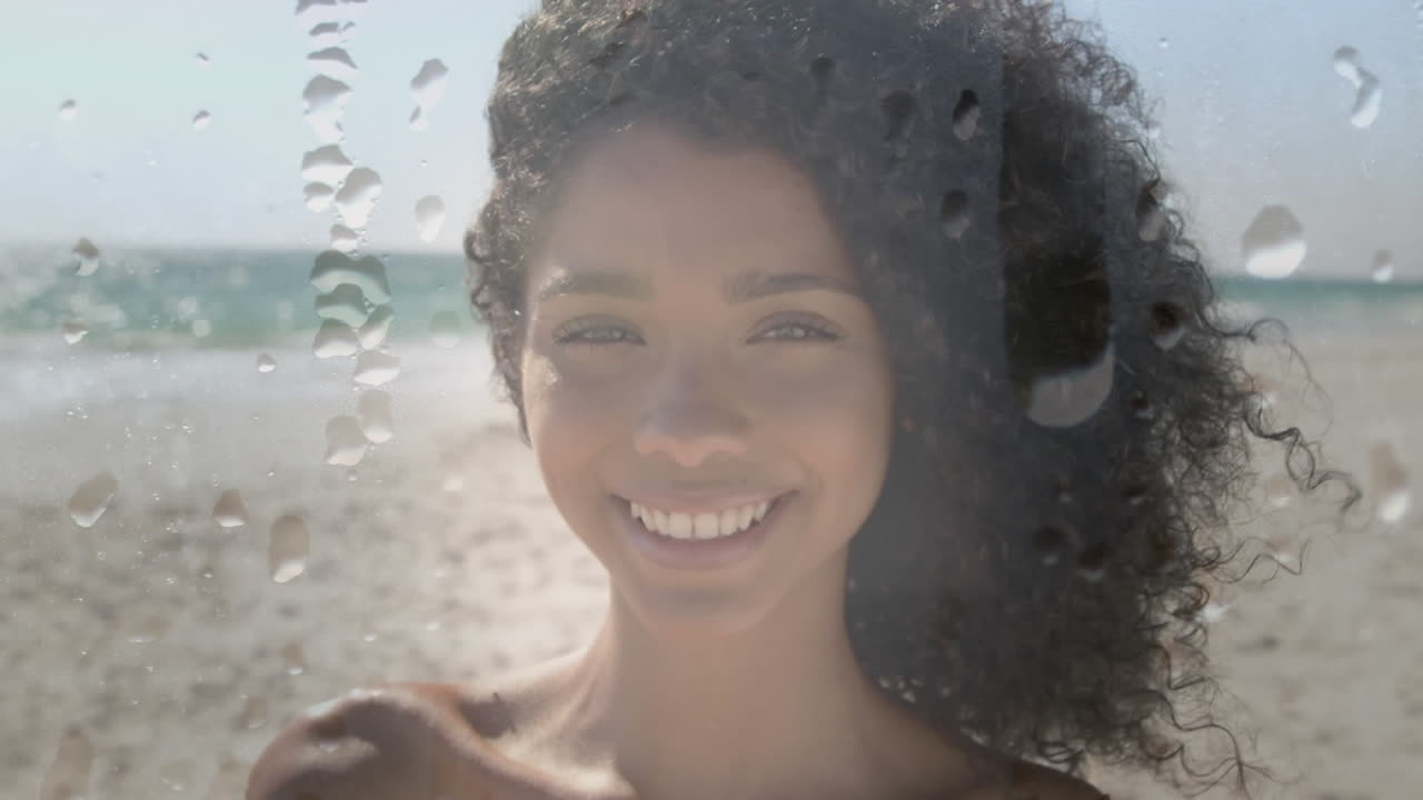 Animação de mulher birracial sorridente na praia sobre gotas