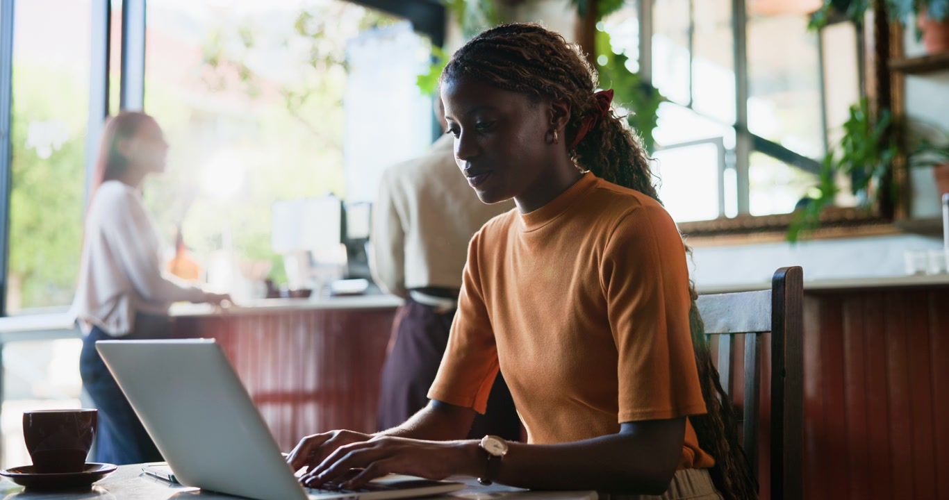 Young Woman Working on Laptop in a Cafe