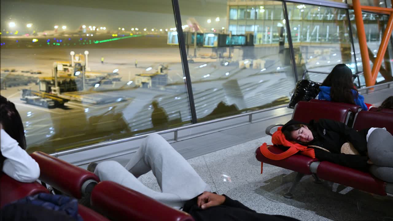 Passengers Sleeping in Airport Terminal at Night