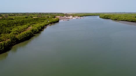 aerial panorama above river gambia path of stala adventures kartong, the gambia africa, wide water channel with forest coastline, establishing shot
