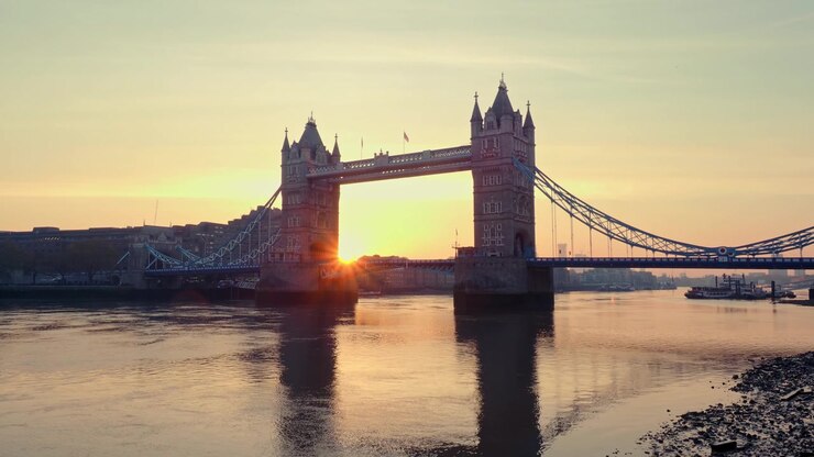Tower Bridge et la Tamise au lever du soleil. Vue grand angle du Tower Bridge avec le soleil apparaissant juste derrière au petit matin.