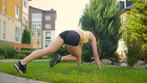 joven mujer atlética está entrenando en el parque usando aparatos haciendo ejercicio de escalador de montaña trabajando duro para mantener la forma del cuerpo en aislamiento