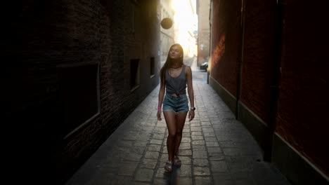 mujer caminando por un estrecho callejón urbano