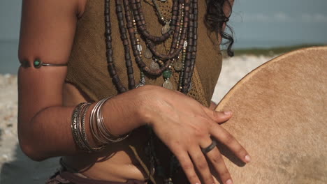 Vista-Aislada-De-Las-Manos-De-La-Mujer-Tocando-El-Instrumento-De-Tambor-étnico-En-La-Playa-En-Cámara-Lenta