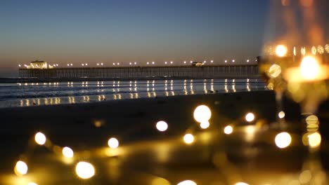 candle flame lights in glass, romantic beach date by ocean waves, summer sea. candlelight on sand.