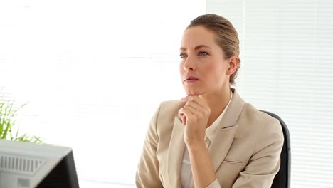 Serious-businesswoman-working-at-her-desk