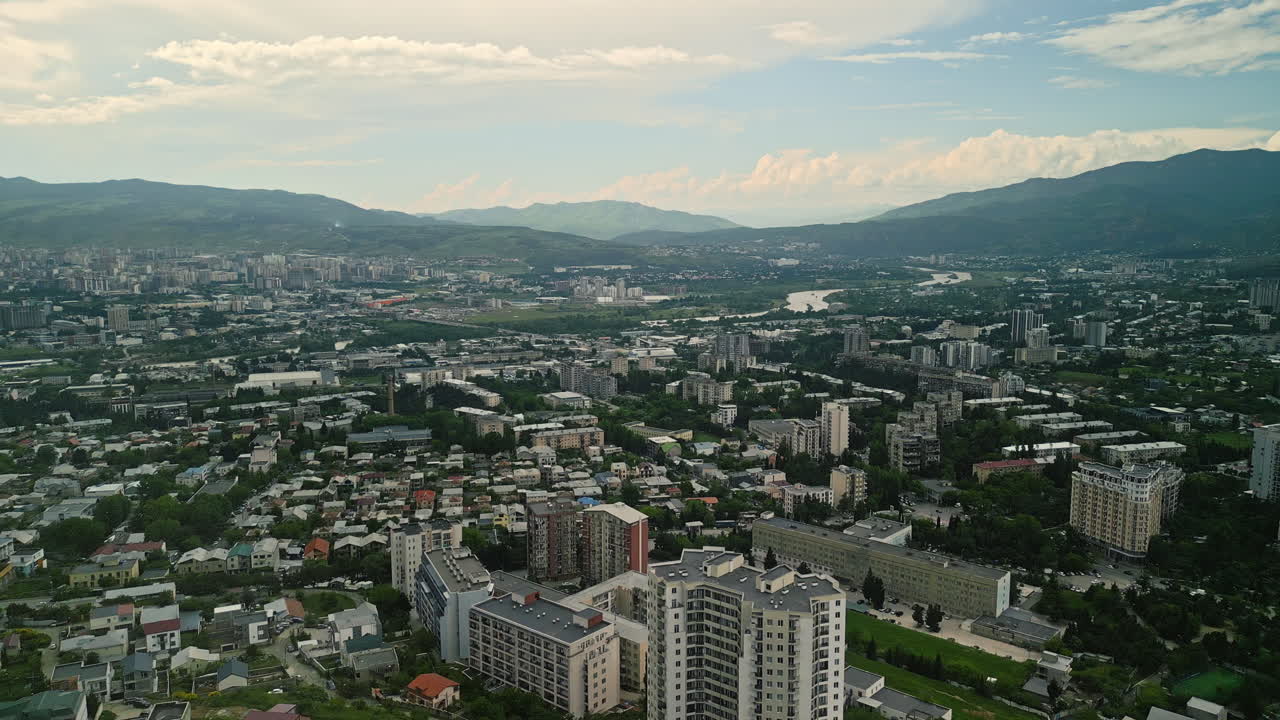 Aerial View of a City with River and Mountains in the Background