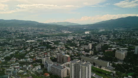 aerial view of a city with river and mountains in the background