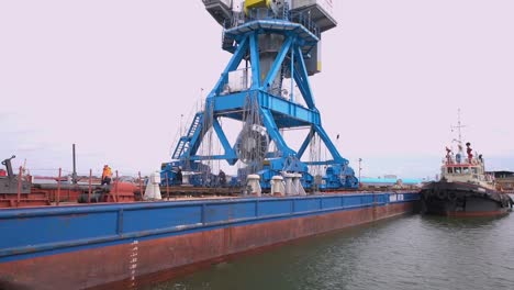 barge being loaded with a crane at a port