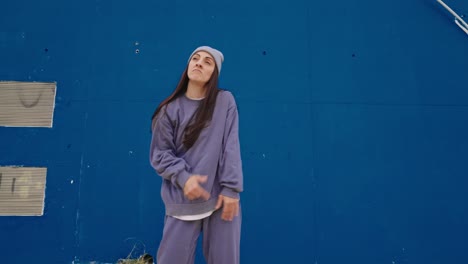 woman dancing in front of blue wall