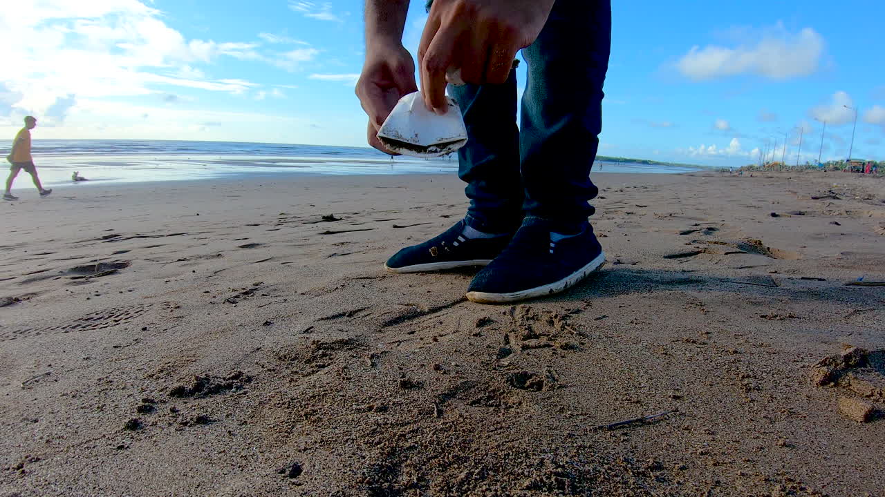 해변 쓰레기에서 쓰레기를 수거하는 사람 자원 봉사