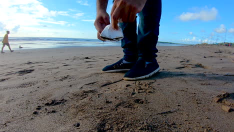 una persona voluntaria recogiendo basura en la basura de la playa