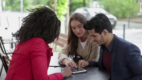 pareja joven deslizando imágenes en la tableta, discutiendo variantes