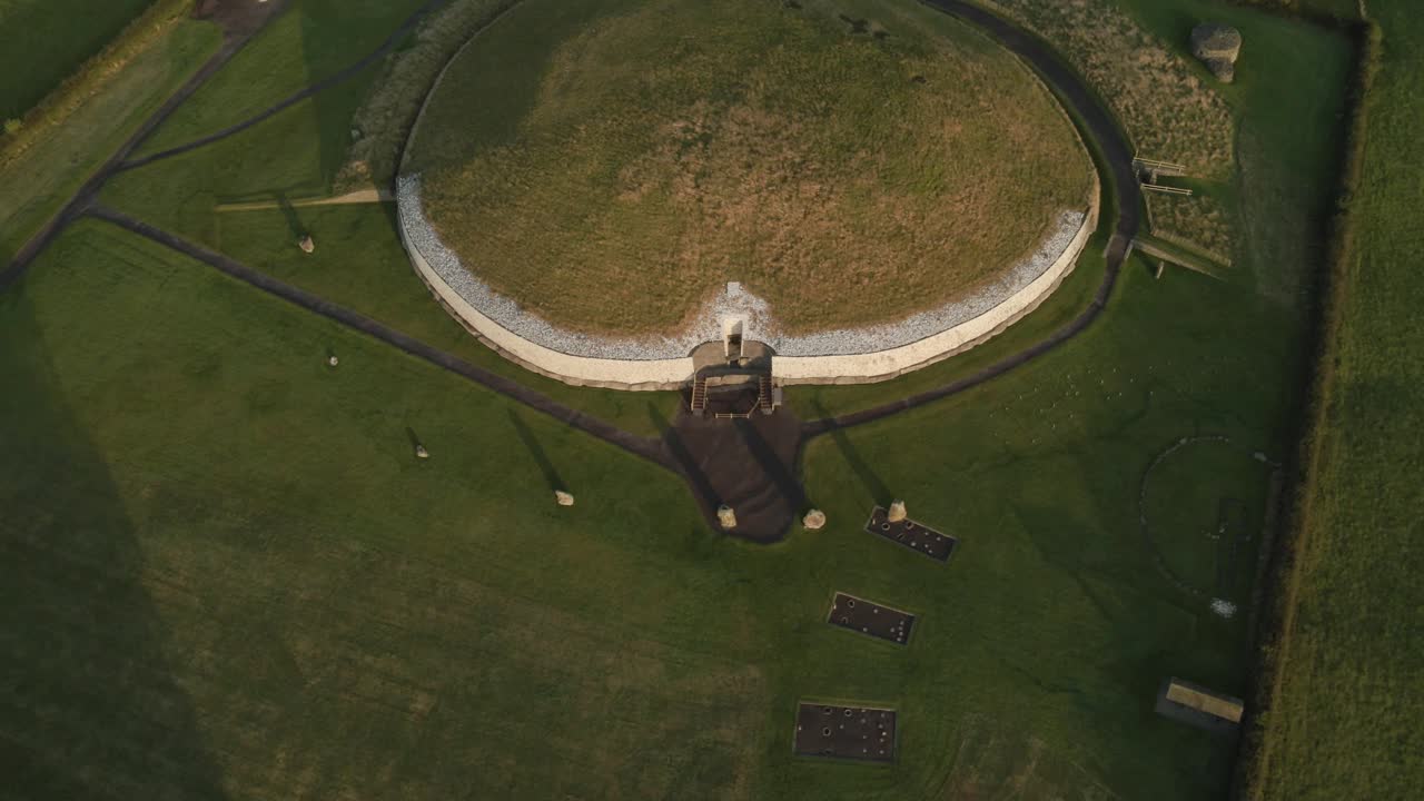 Newgrange ancient monument in ireland during sunrise with long shadows cast., aerial view