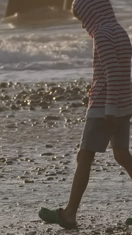 child playing on the beach at sunset