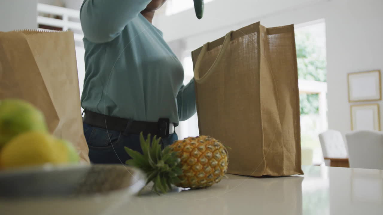 Woman unpacking groceries in modern kitchen, showing circular scanning animation for food tech