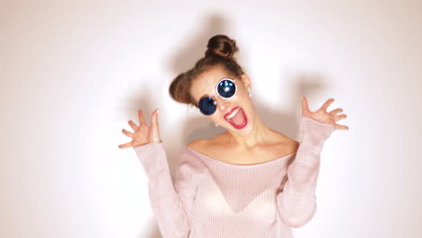 woman in a cropped sweater and bikini posing in front of a white background