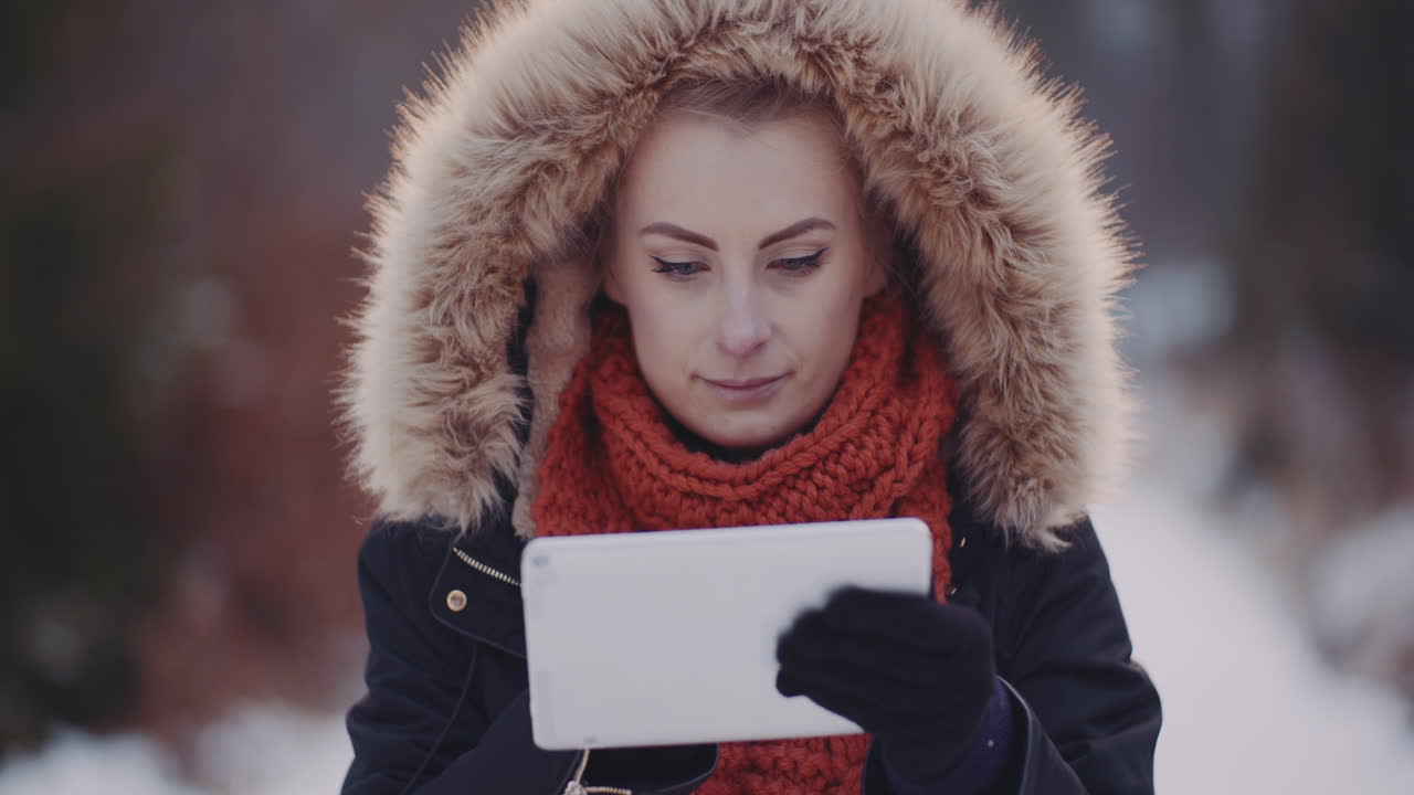 겨울 야외에서 디지털 태블릿을 사용하는 긍정적인 여성 2