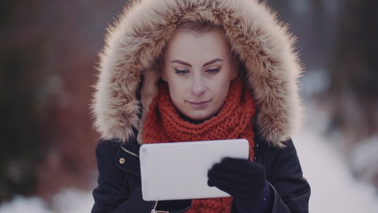 Donna positiva che usa un tablet digitale all'aperto in inverno 2