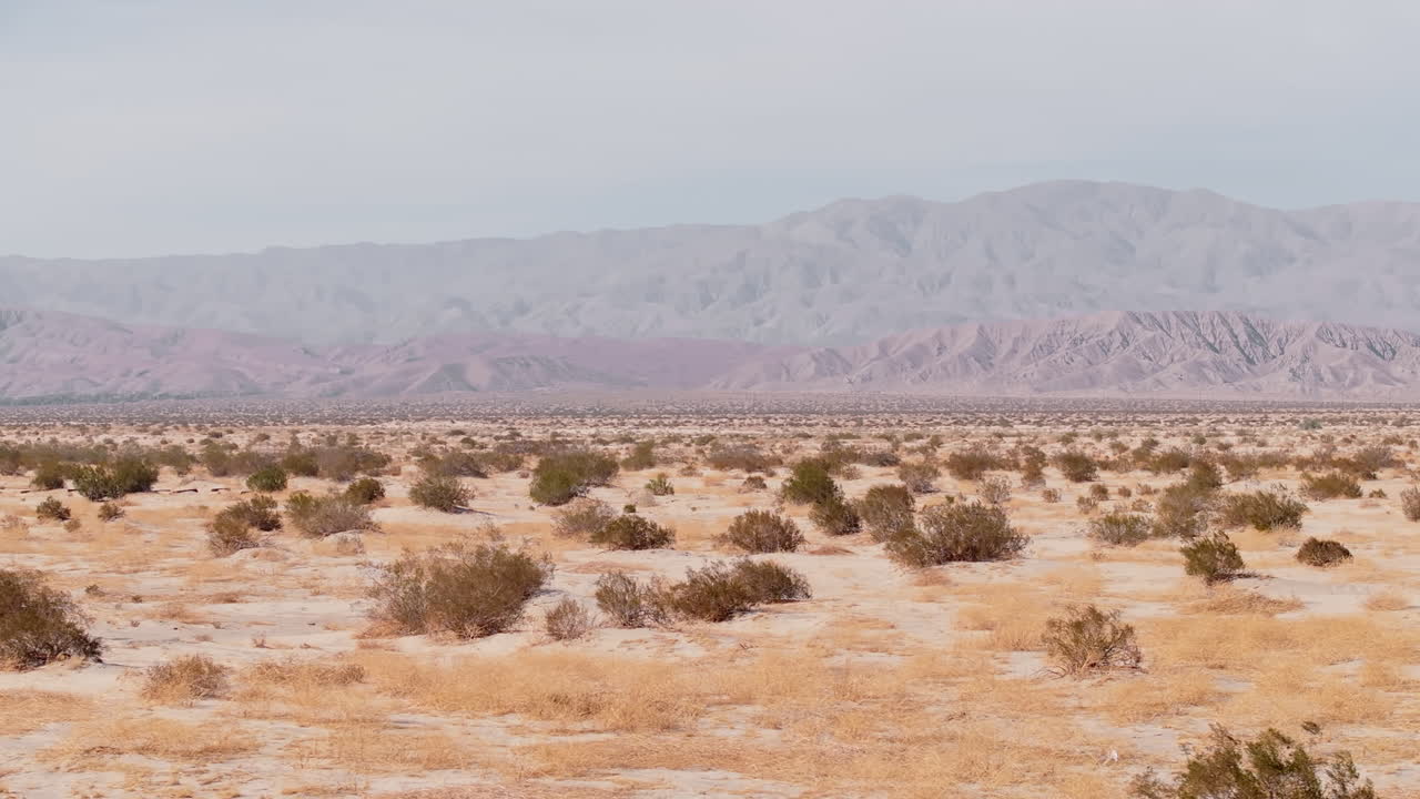 Explore the vast and tranquil Barstow desert in California. This stunning landscape features arid terrain, sparse vegetation, and majestic mountains in the background, showcasing natural beauty