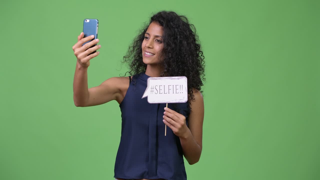 Young beautiful Hispanic businesswoman using phone