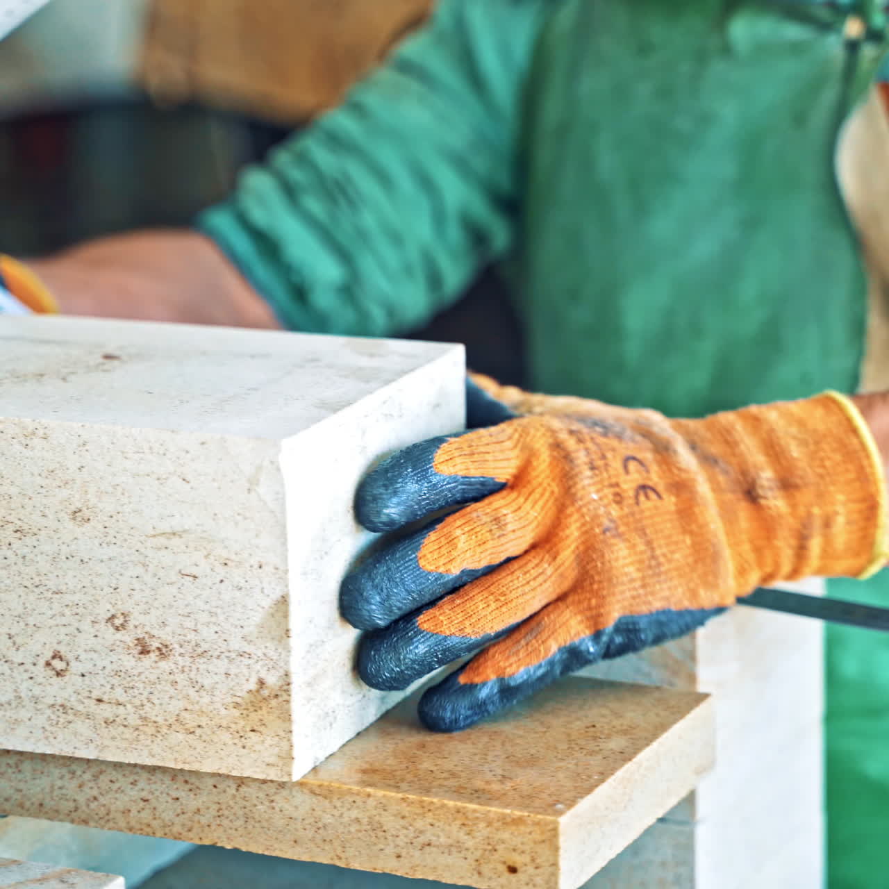 Man in protective uniform with mask measures the stone slabs in factory. Worker with the ruler is measuring cutted stone slabs in the industrial manufacture.