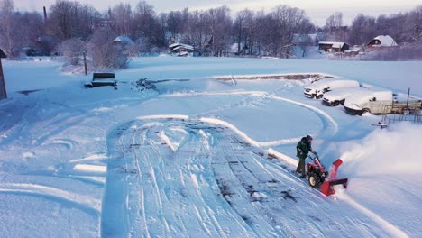 Mann,-Der-Schnee-Mit-Industrietraktor-In-Der-Wintersaison-Pflügt,-Luftdrohnenansicht